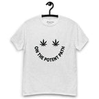 Ash grey colour t-shirt on a hanger featuring curved text reading "ON THE POTENT PATH" in the form of a smiley face and two black cannabis leaves above to represent the eyes