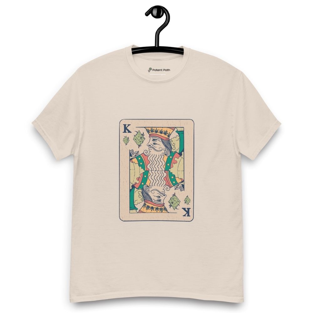 Beige T-shirt on a hanger featuring a vintage-style playing card design of the King holding a weed joint, with the suit replaced by cannabis leaves