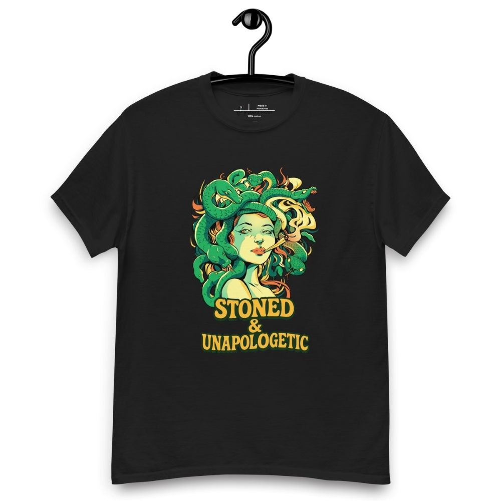 Black T-shirt on a hanger featuring a Medusa head smoking a joint with green snake hair, and the text "STONED & UNAPOLOGETIC" below