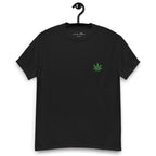 Black t-shirt with a green leaf design on a hanger against a white background