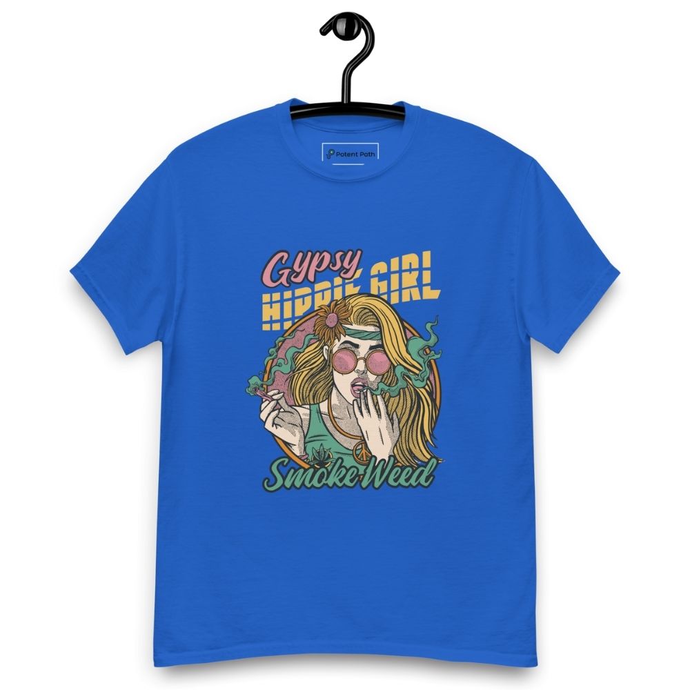 Blue T-shirt on a hanger featuring a colourful illustration of a woman with long blonde hair, round pink sunglasses, and a flower in her hair, smoking weed with swirling smoke around her and text "Gypsy Hippie Girl" above and "Smoke Weed" below