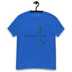 Blue t-shirt on a hanger featuring the phrase "Walking The Potent Path Slowly" in white text across the chest, with a vertical trail of small green footprints with cannabis leaves inside between "Path" and "Slowly"