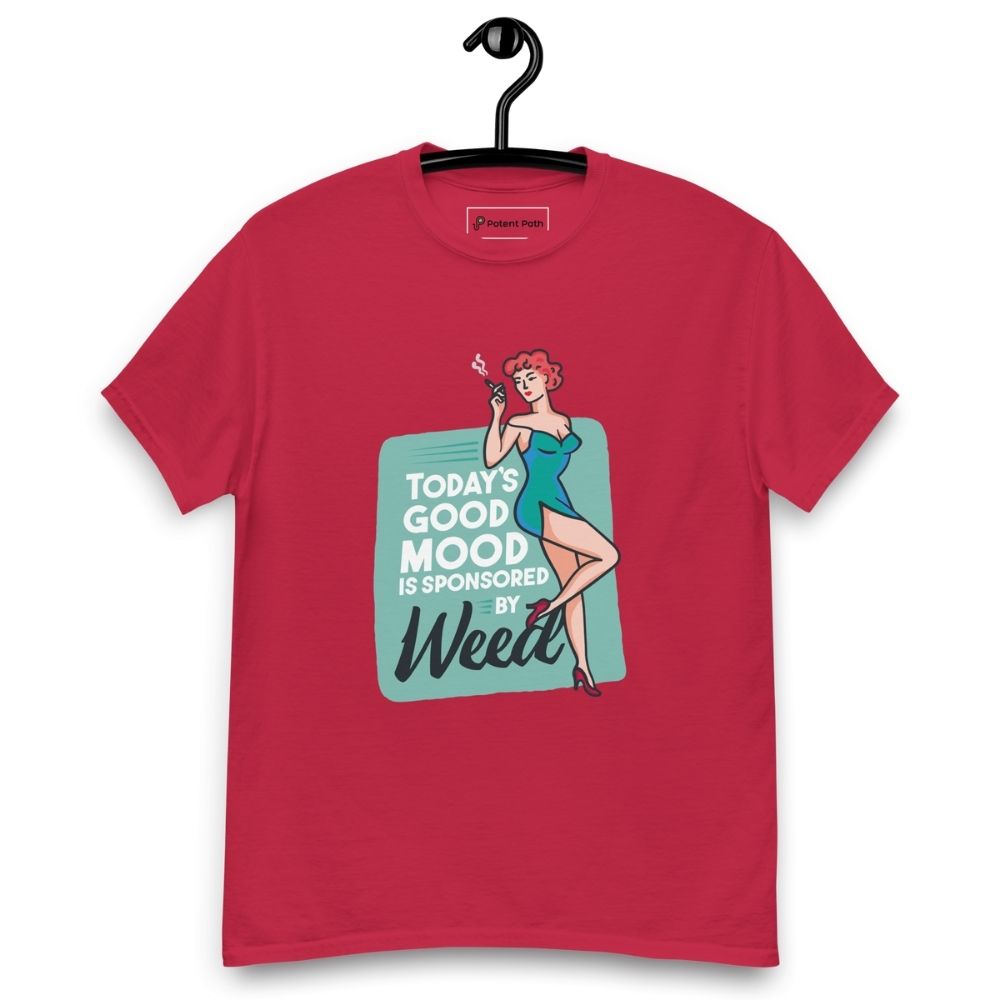 Cardinal red T-shirt on a hanger featuring a retro-style illustration of a woman in a teal dress holding a smoking joint, next to the text “TODAY'S GOOD MOOD IS SPONSORED BY Weed"