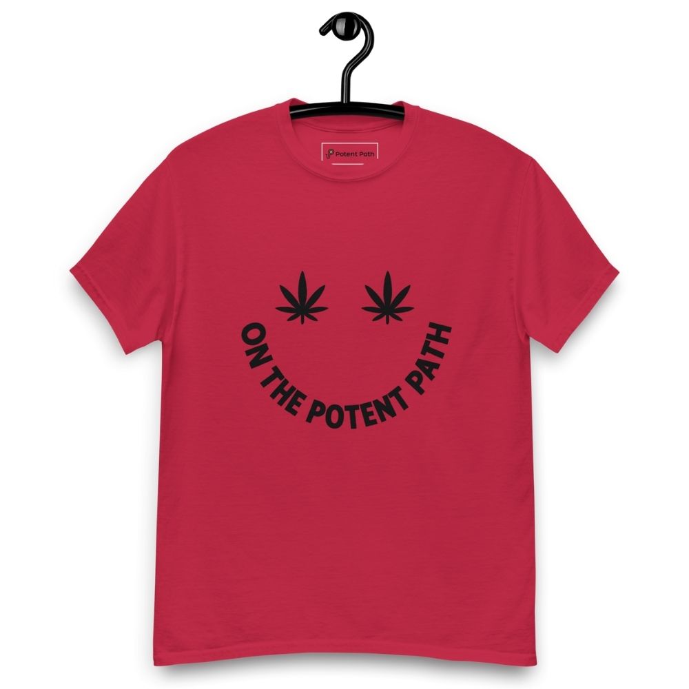 Cardinal red t-shirt on a hanger featuring curved text reading "ON THE POTENT PATH" in the form of a smiley face and two black cannabis leaves above to represent the eyes