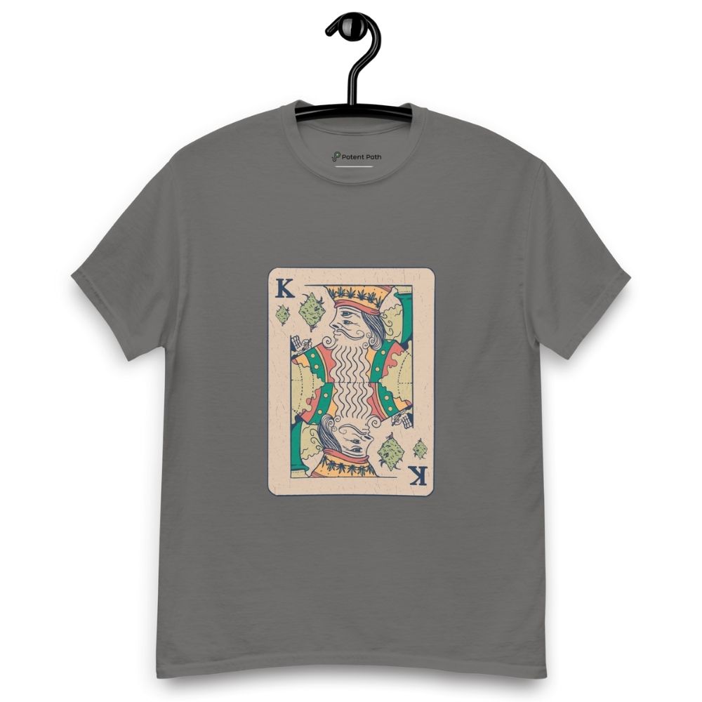 Charcoal grey T-shirt on a hanger featuring a vintage-style playing card design of the King holding a weed joint, with the suit replaced by cannabis leaves