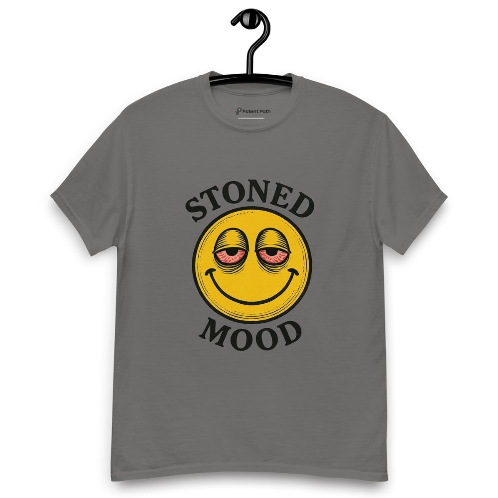 Grey T-shirt on a hanger with a yellow smiley face with droopy, bloodshot eyes and the phrase "STONED MOOD" printed above and below the graphic
