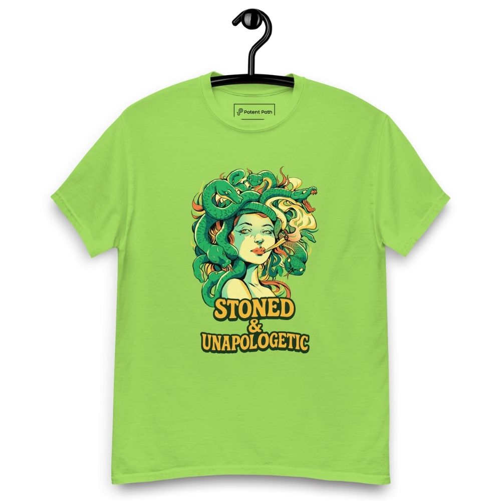 Lime green T-shirt on a hanger featuring a Medusa head smoking a joint with green snake hair, and the text "STONED & UNAPOLOGETIC" below