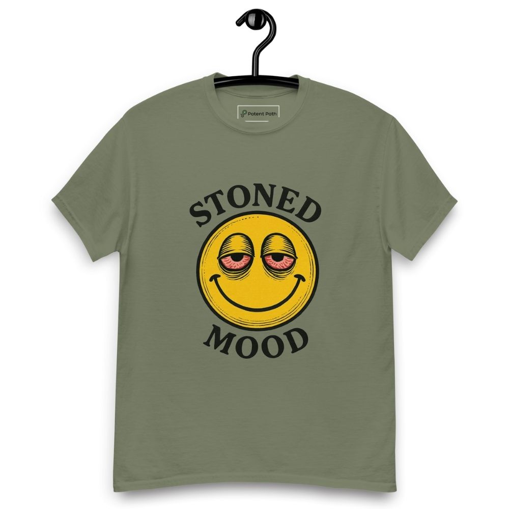 Green T-shirt on a hanger with a yellow smiley face with droopy, bloodshot eyes and the phrase "STONED MOOD" printed above and below the graphic