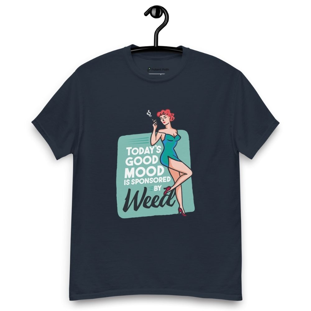 Navy blue T-shirt on a hanger featuring a retro-style illustration of a woman in a teal dress holding a smoking joint, next to the text “TODAY'S GOOD MOOD IS SPONSORED BY Weed"