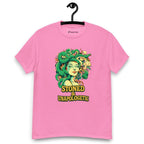 Pink T-shirt on a hanger featuring a Medusa head smoking a joint with green snake hair, and the text "STONED & UNAPOLOGETIC" below