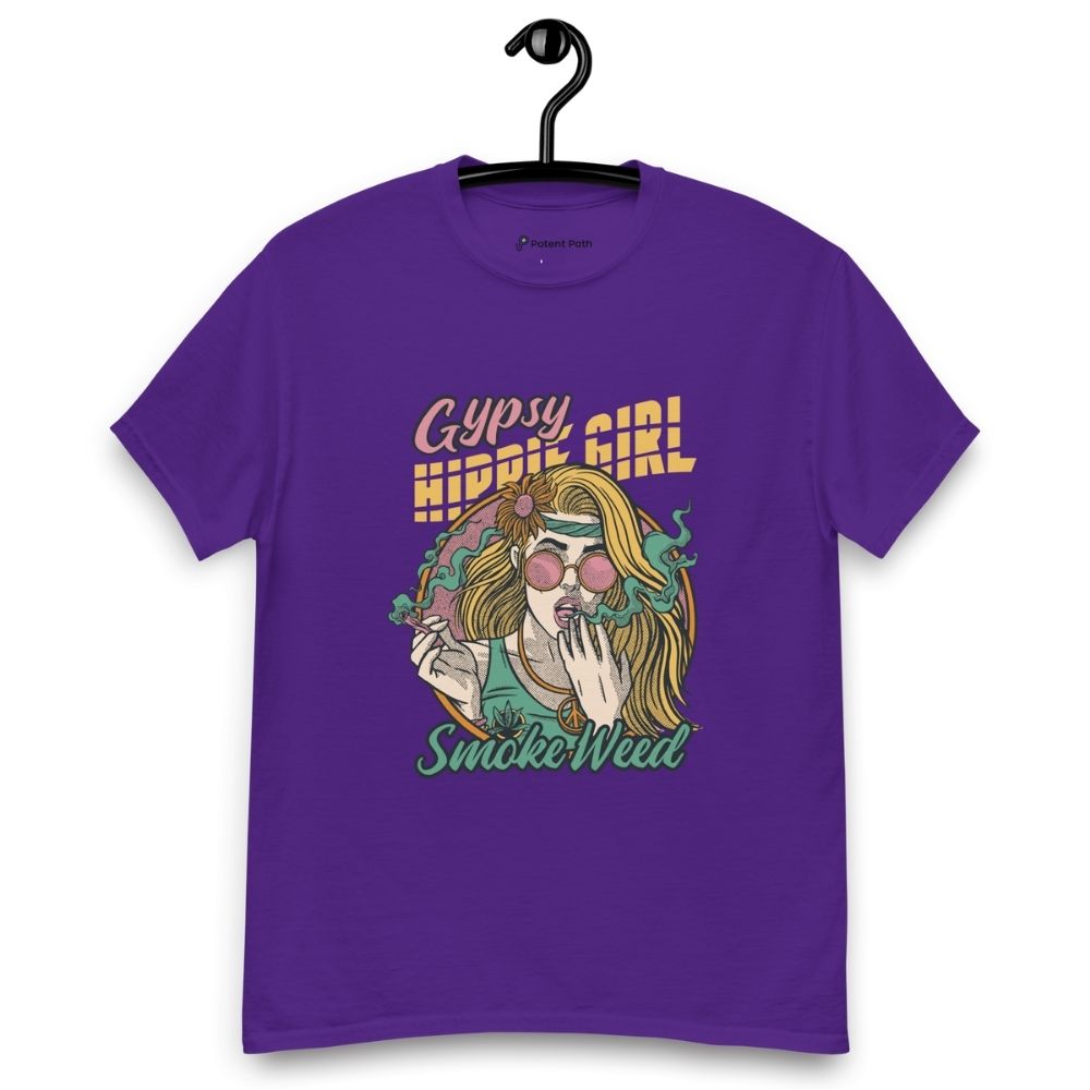 Purple T-shirt on a hanger featuring a colourful illustration of a woman with long blonde hair, round pink sunglasses, and a flower in her hair, smoking weed with swirling smoke around her and text "Gypsy Hippie Girl" above and "Smoke Weed" below