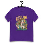 Purple T-shirt on a hanger featuring a colourful illustration of a woman with long blonde hair, round pink sunglasses, and a flower in her hair, smoking weed with swirling smoke around her and text "Gypsy Hippie Girl" above and "Smoke Weed" below