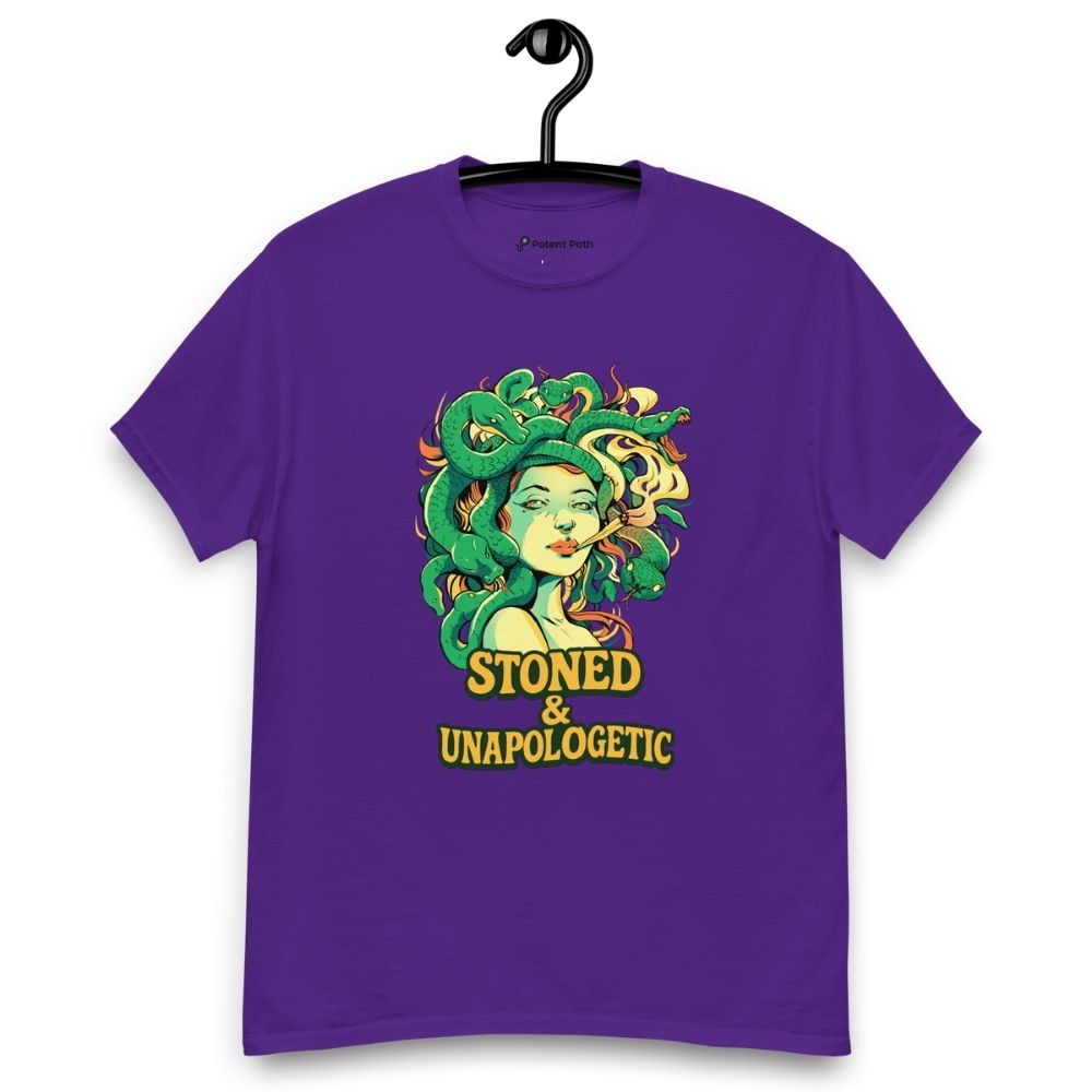 Purple T-shirt on a hanger featuring a Medusa head smoking a joint with green snake hair, and the text "STONED & UNAPOLOGETIC" below