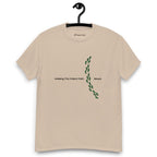 Sandy colour t-shirt on a hanger featuring the phrase "Walking The Potent Path Slowly" in white text across the chest, with a vertical trail of small green footprints with cannabis leaves inside between "Path" and "Slowly"