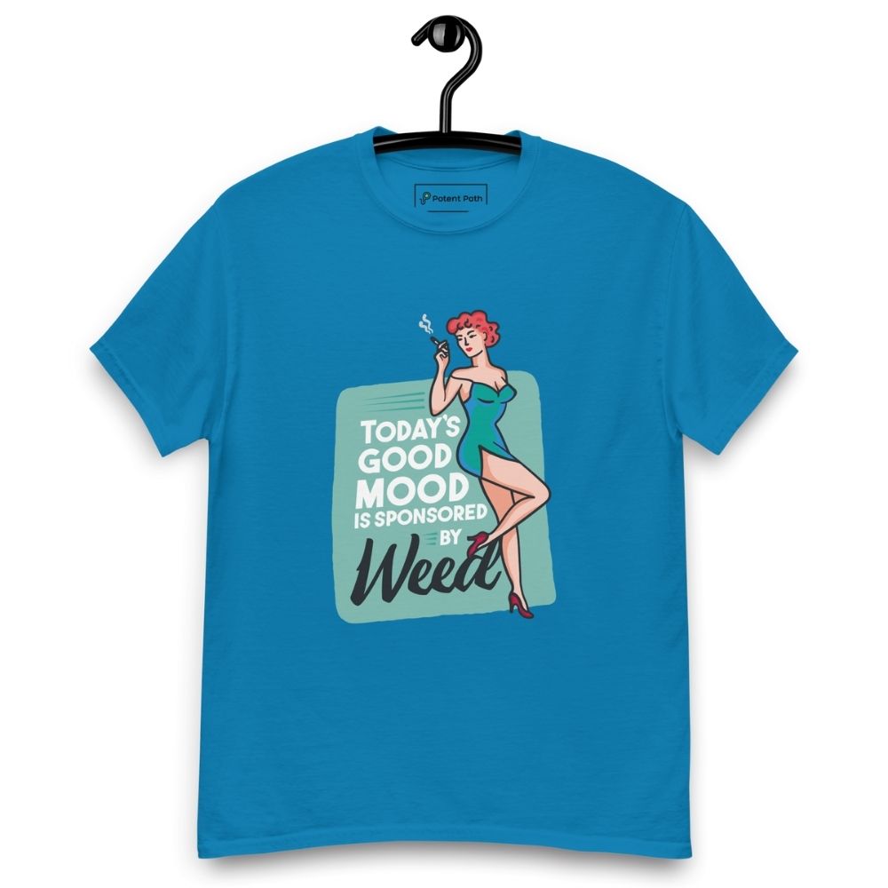Sapphire blue T-shirt on a hanger featuring a retro-style illustration of a woman in a teal dress holding a smoking joint, next to the text “TODAY'S GOOD MOOD IS SPONSORED BY Weed"