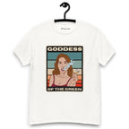 White T-shirt on a hanger featuring a retro-style illustration of a woman smoking a joint, set against colourful horizontal stripes, with the text "GODDESS" above and "OF THE GREEN" below the artwork