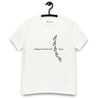White t-shirt on a hanger featuring the phrase "Walking The Potent Path Slowly" in white text across the chest, with a vertical trail of small green footprints with cannabis leaves inside between "Path" and "Slowly"